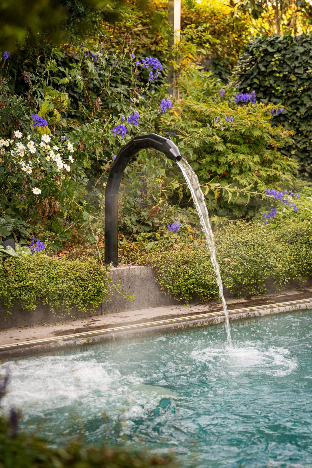 Gartenpool mit Wasserspeier und Staudenbeet – Richter Garten