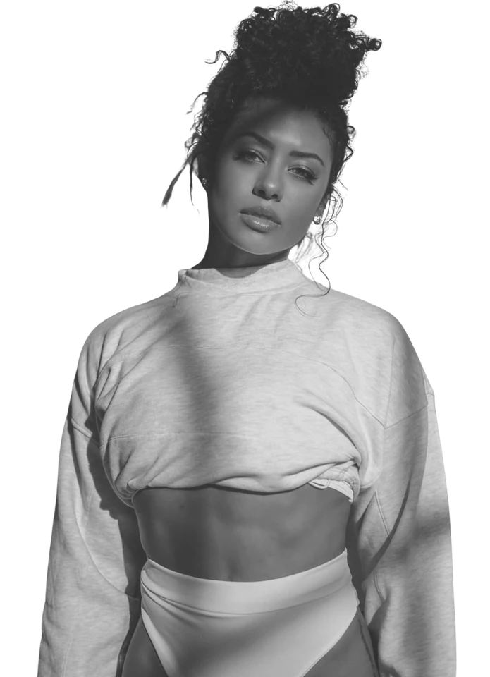 Black-and-white portrait of a woman with her hair up, wearing a light cropped sweatshirt.