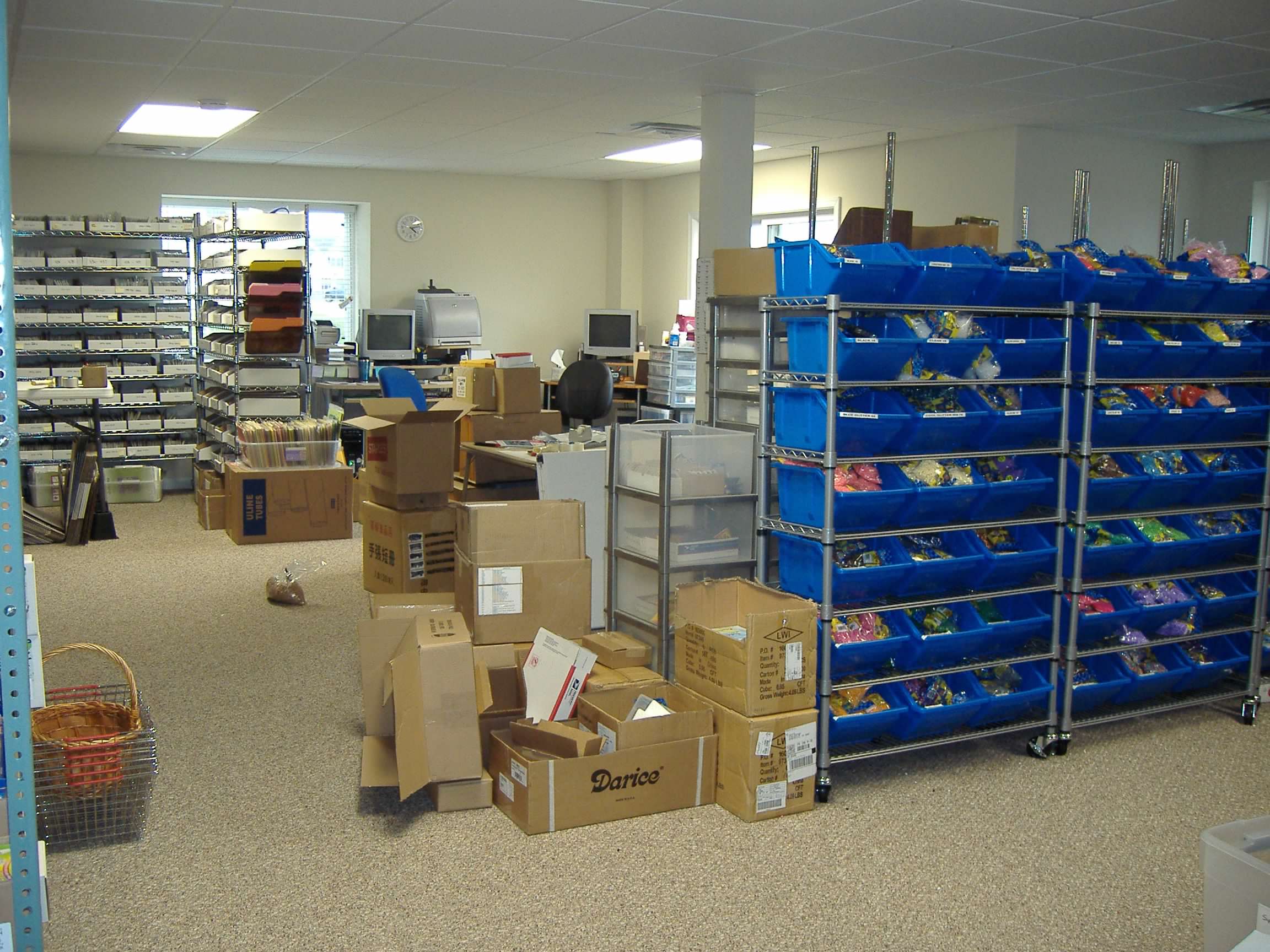 Shelves and bins of craft supplies in our early inventory room