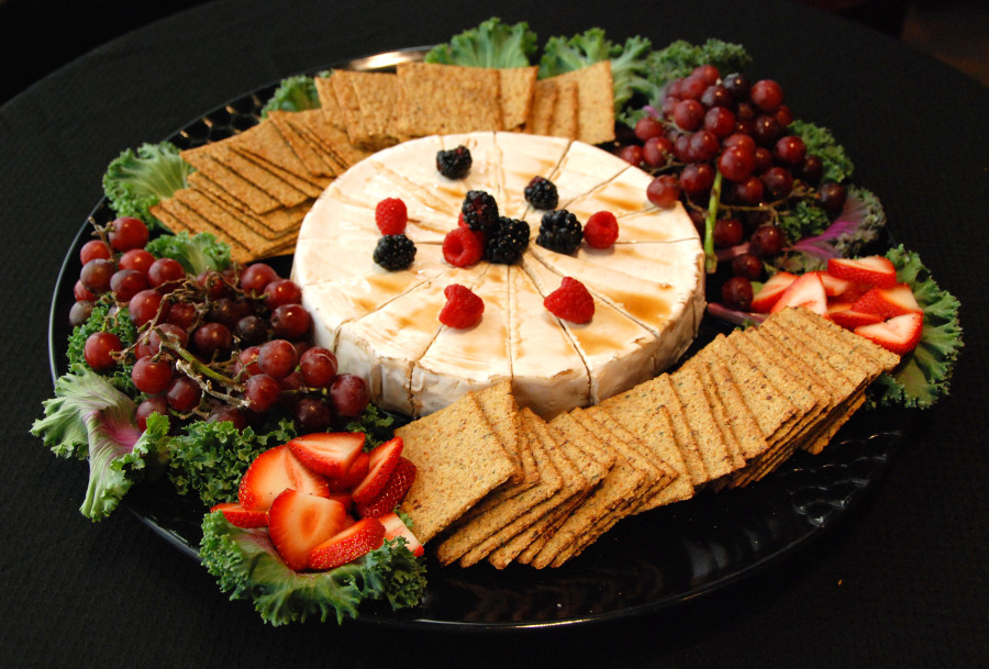 Catering platter of baked brie with fruit and crackers
