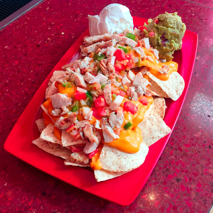 Tortilla chips loaded with nacho cheese, pico de gallo and toppings
