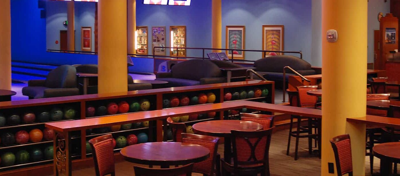 Main Room lounge tables beside the ball racks and bowling lanes