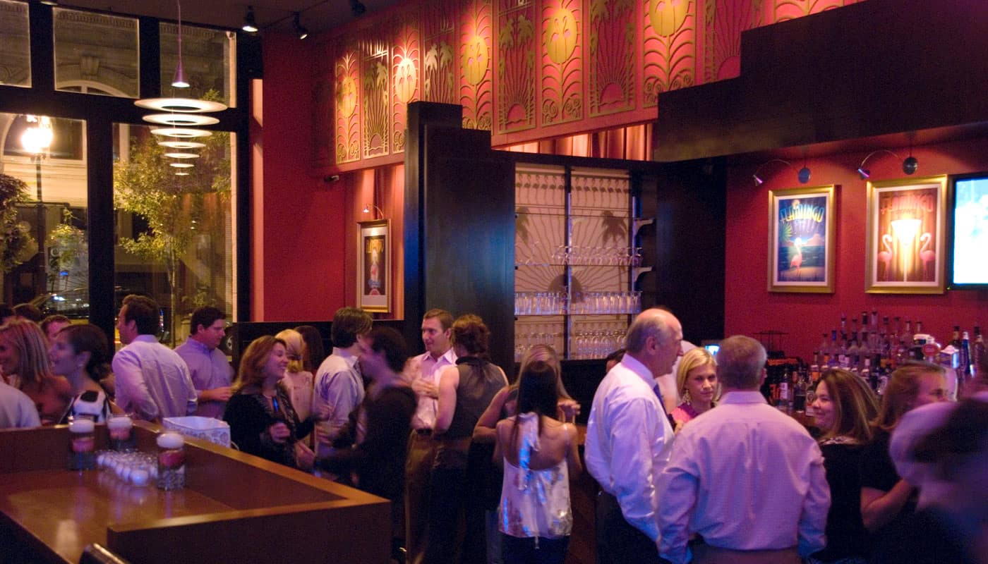 A lively crowd mingling at a private party in the Palm Room