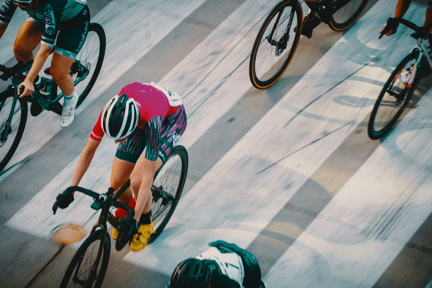 Cyclists racing close together on a track, seen from above