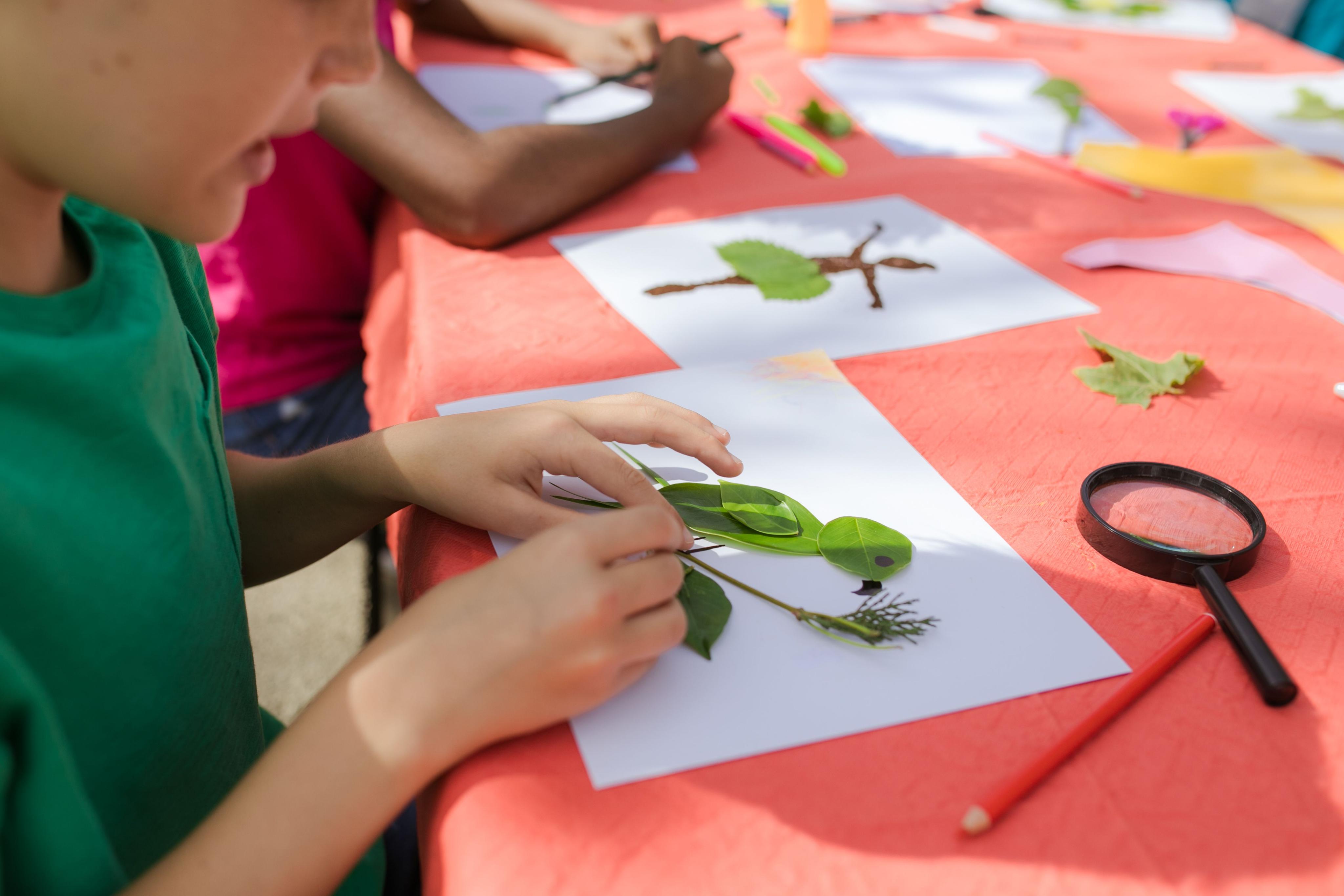 Children examining leaves with a magnifying glass
