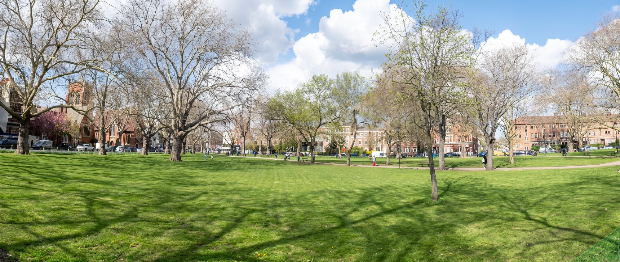 Lawns and trees on Parsons Green with period houses beyond