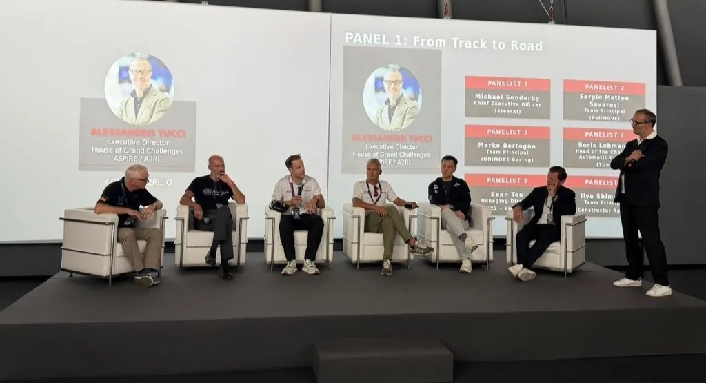 Panel 1, From Track to Road: six panellists and a moderator on stage at the A2RL conference in Imola