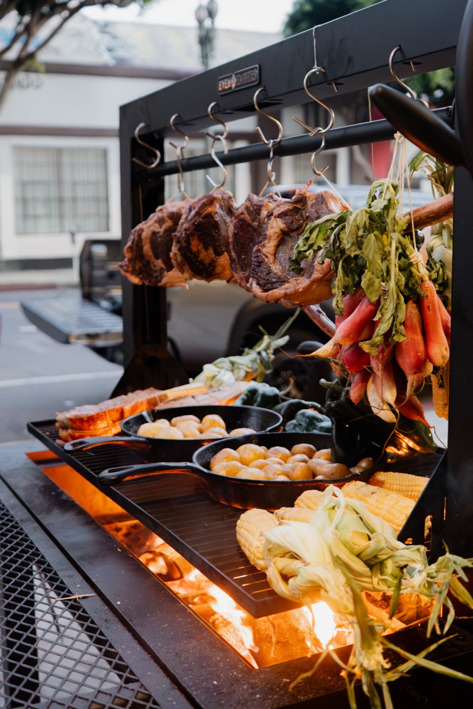 Meat, radishes, potatoes and corn over an open fire