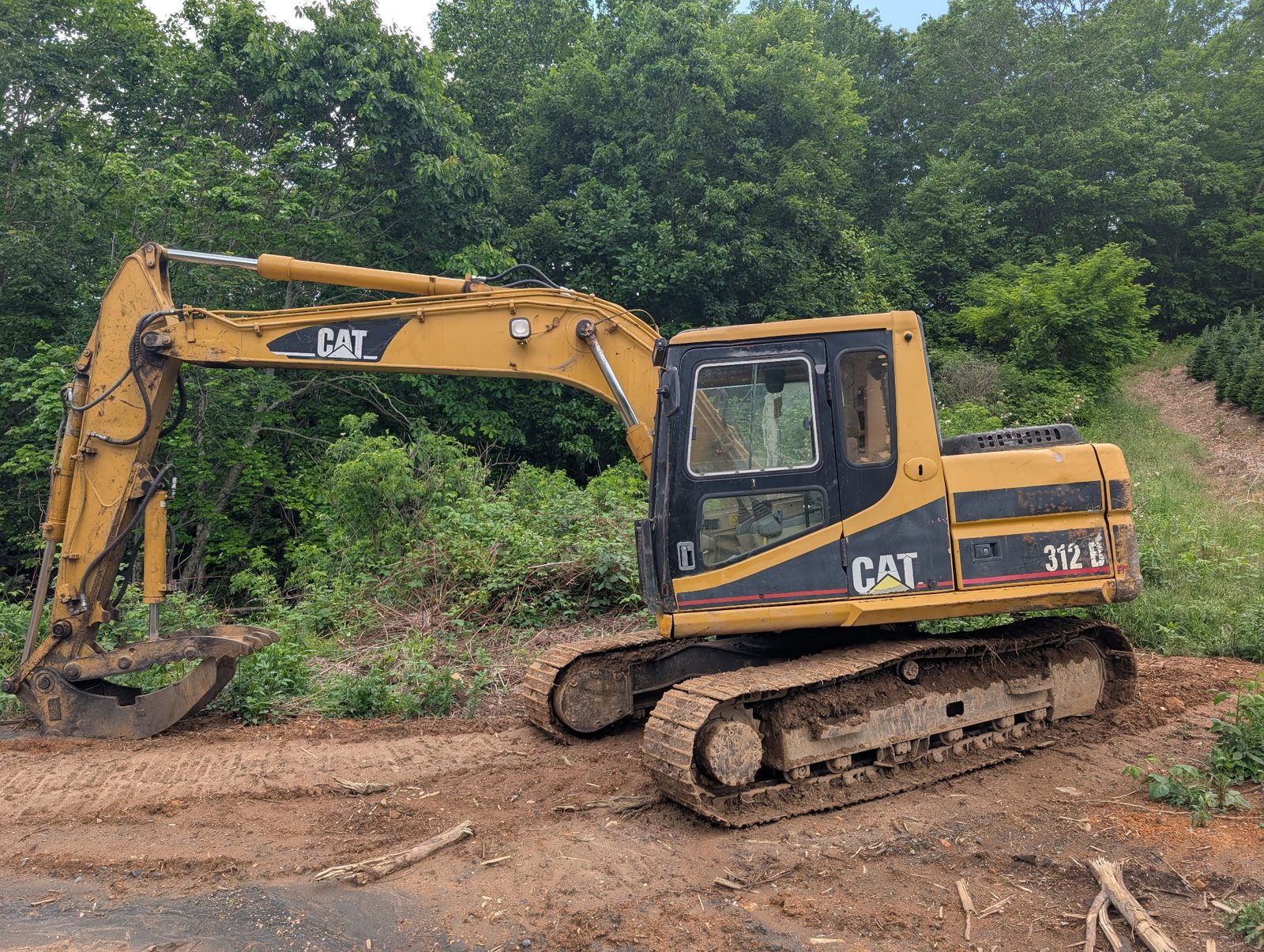 Western Carolina Earthworx CAT 312 excavator on a cleared mountain lot in Avery County, NC