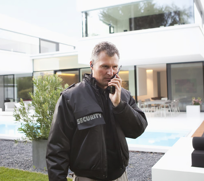 Security guard on a radio call outside a modern property