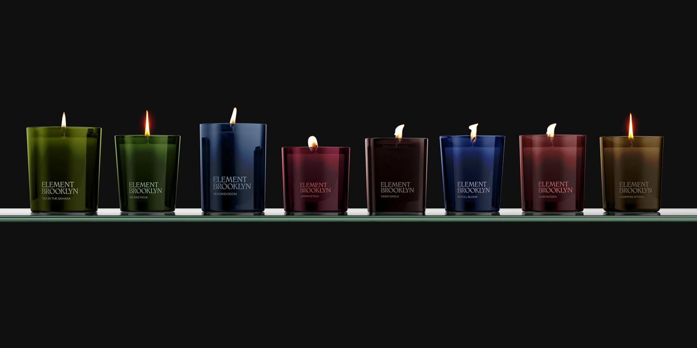 Element Brooklyn scented candles in coloured glass, lined up on a shelf