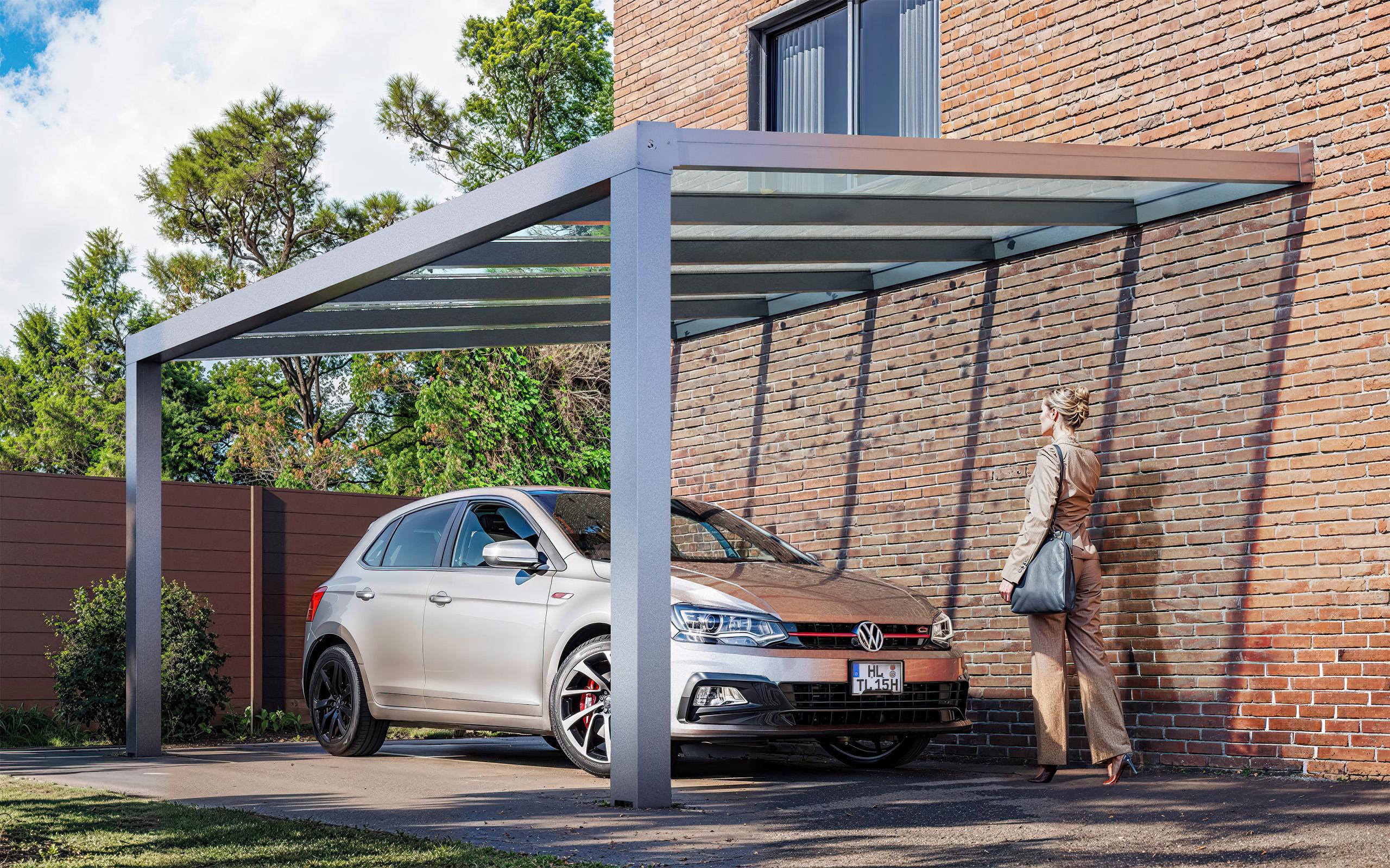 Silver Volkswagen Polo under a glass-roof carport beside a brick wall, image by 35milimetre
