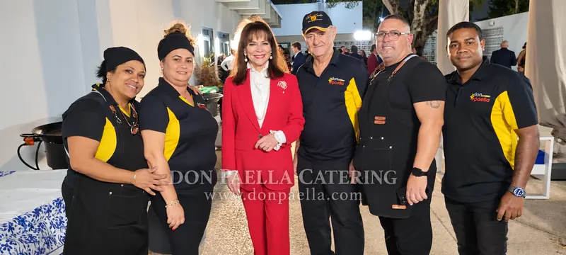 Don Paella catering team posing with a guest at an event