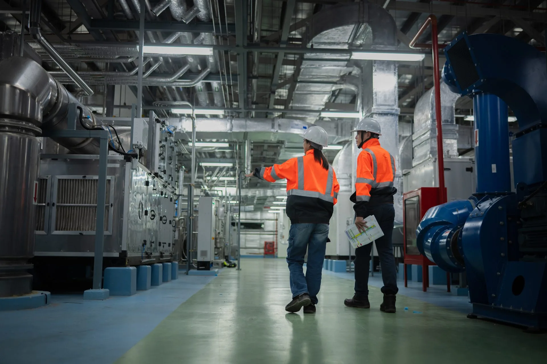 Workers in safety gear inside an industrial facility