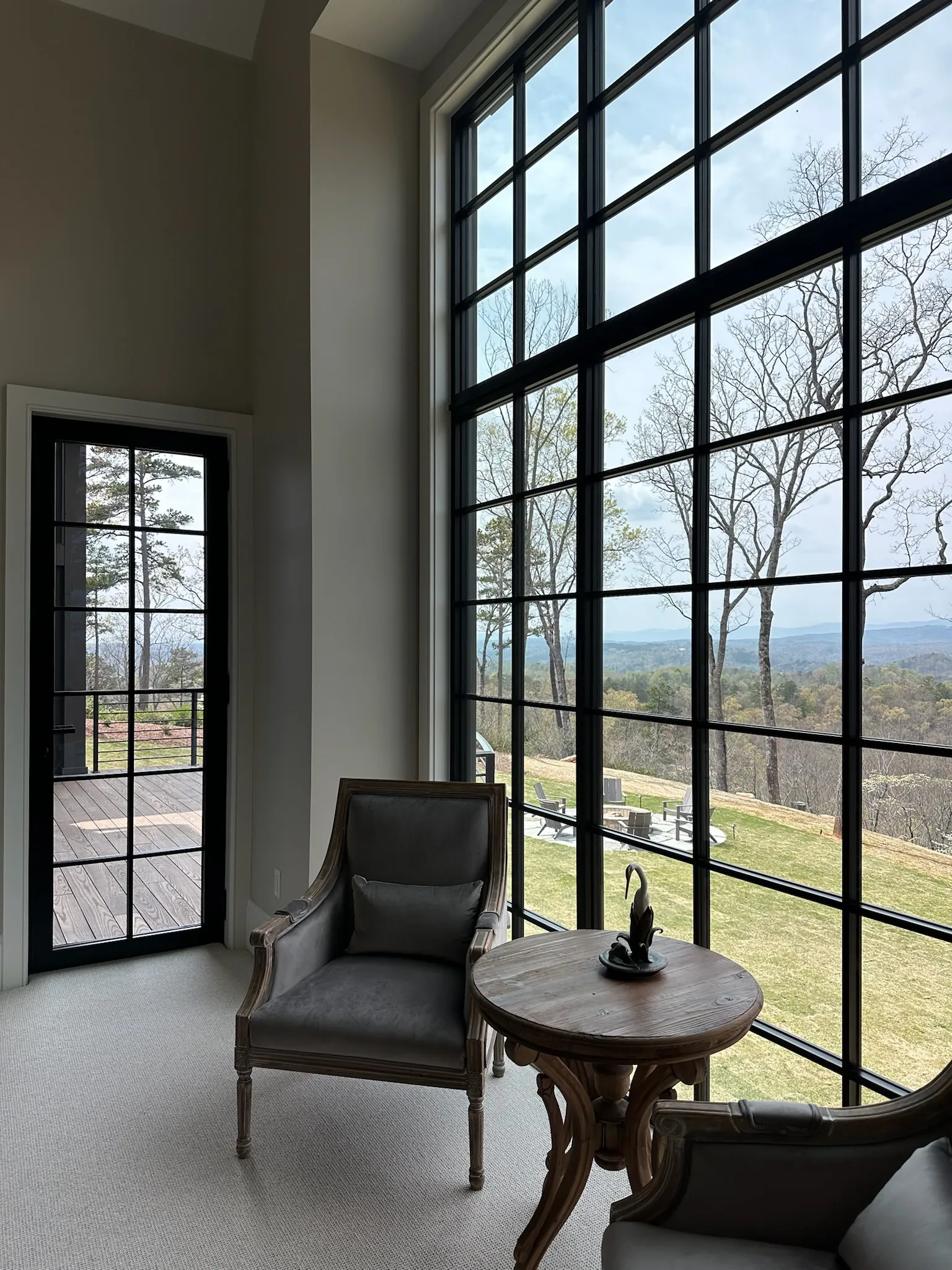 Reynaers SlimLine 38 black steel-look aluminum windows and glass door in a sitting room overlooking a mountain view