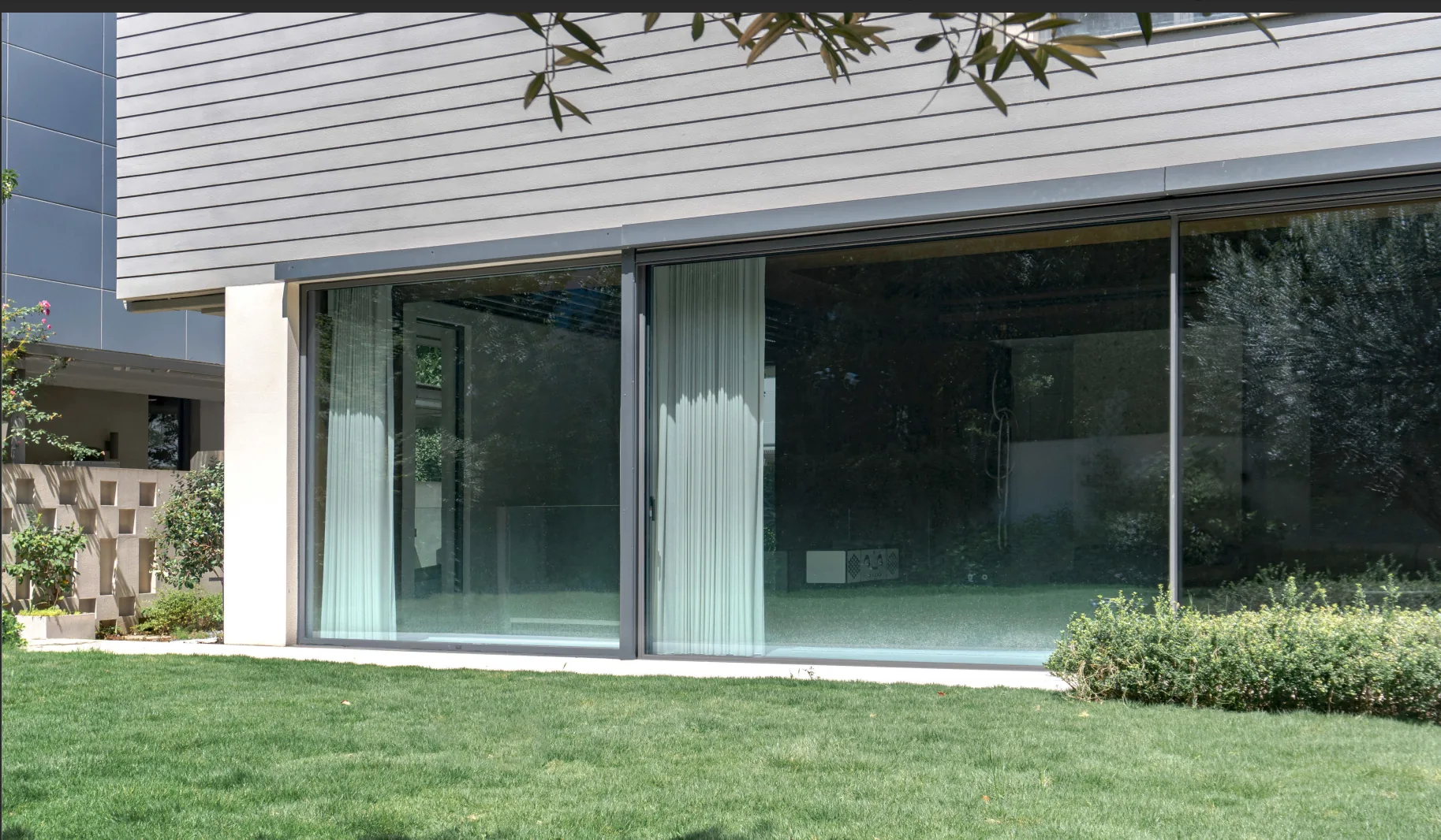 Modern gray-clad house with dark aluminum sliding doors