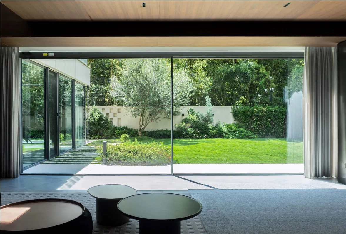 Minimal-frame sliding door opening a living room to the garden