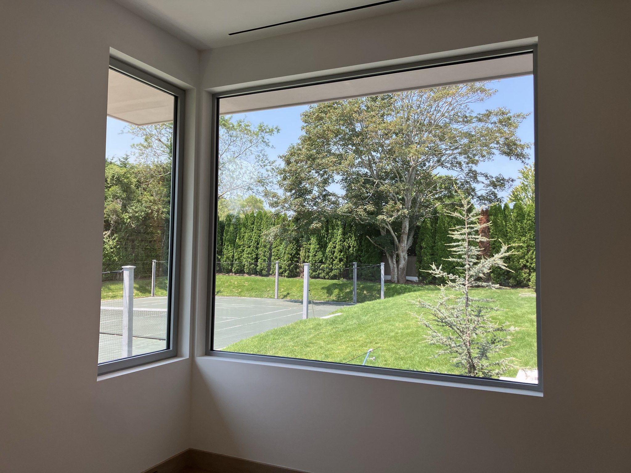 Floor-to-ceiling corner windows framing the garden