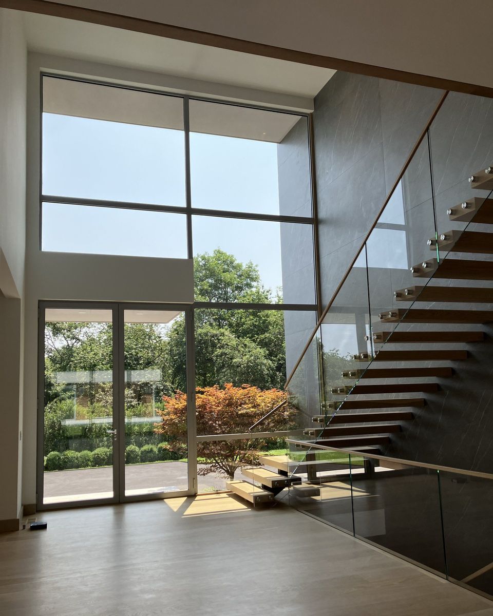 Westline minimal-frame glass wall in a two-story stair hall