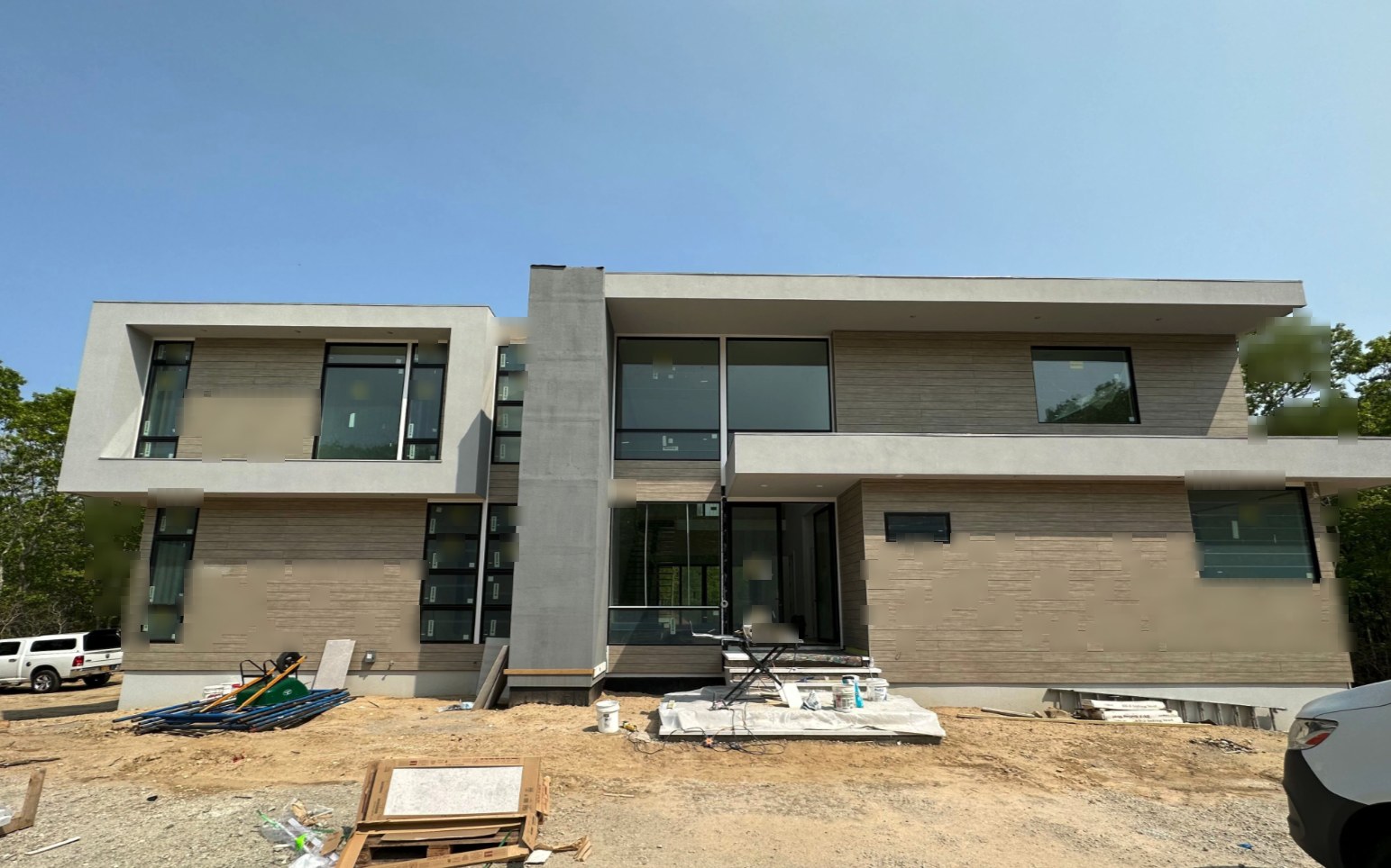Front elevation of a modern home with a single-brand window package and heavy black frames, during construction