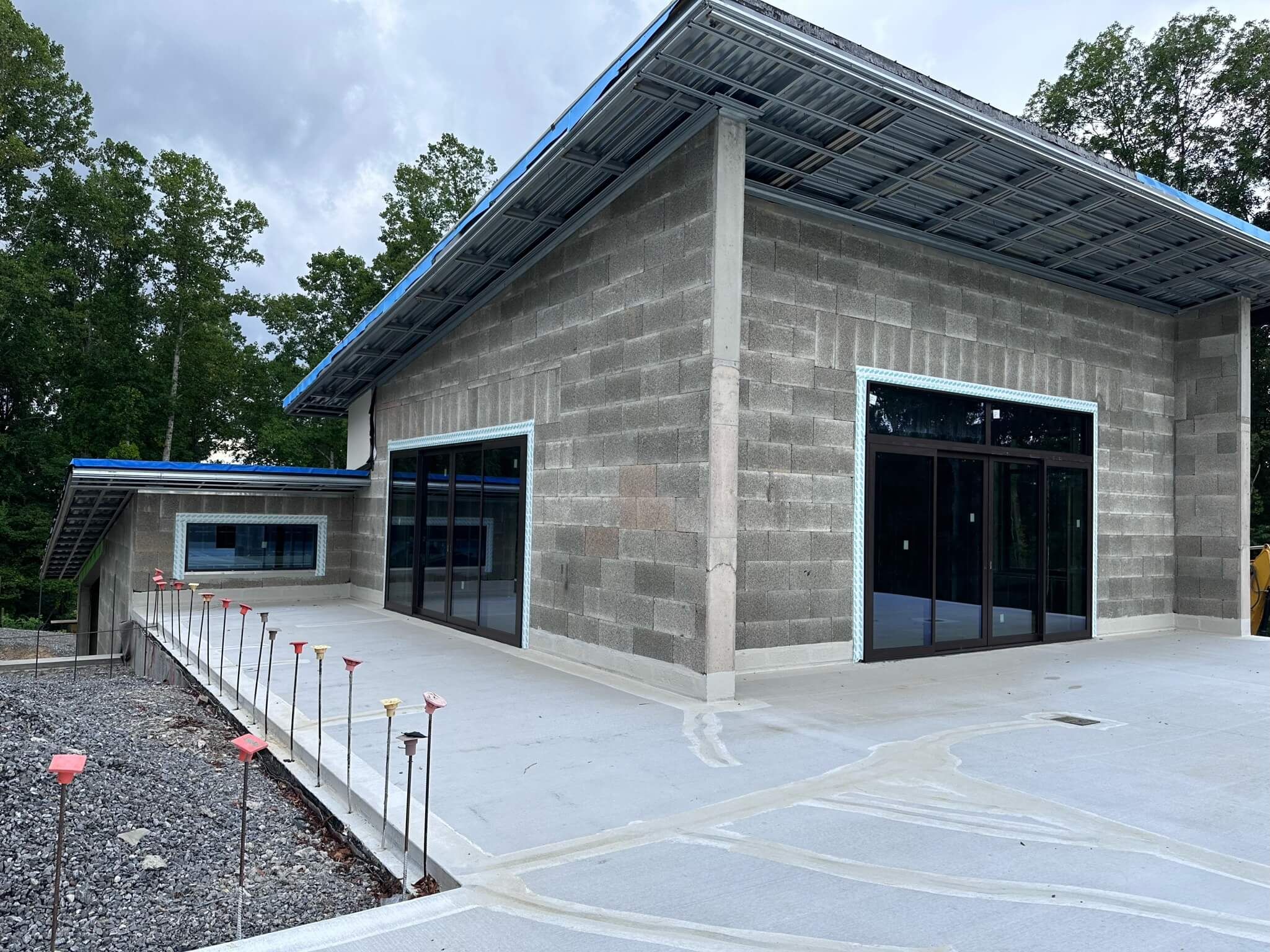 Side of a block home in Fletcher, NC with Westline sliding glass doors and large windows under a sloped roof, during construction