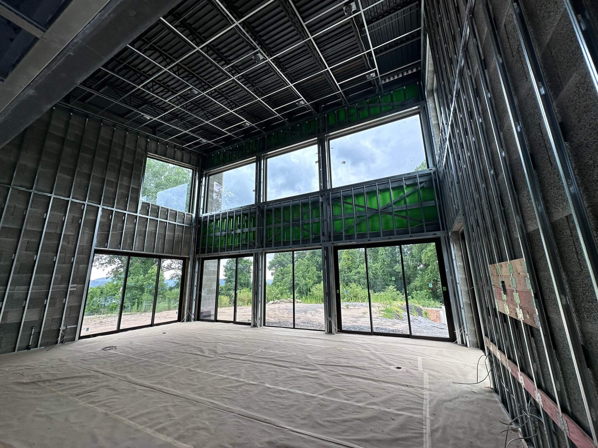 Interior framing of a Fletcher, NC home with a two-level wall of Westline windows looking out to the trees