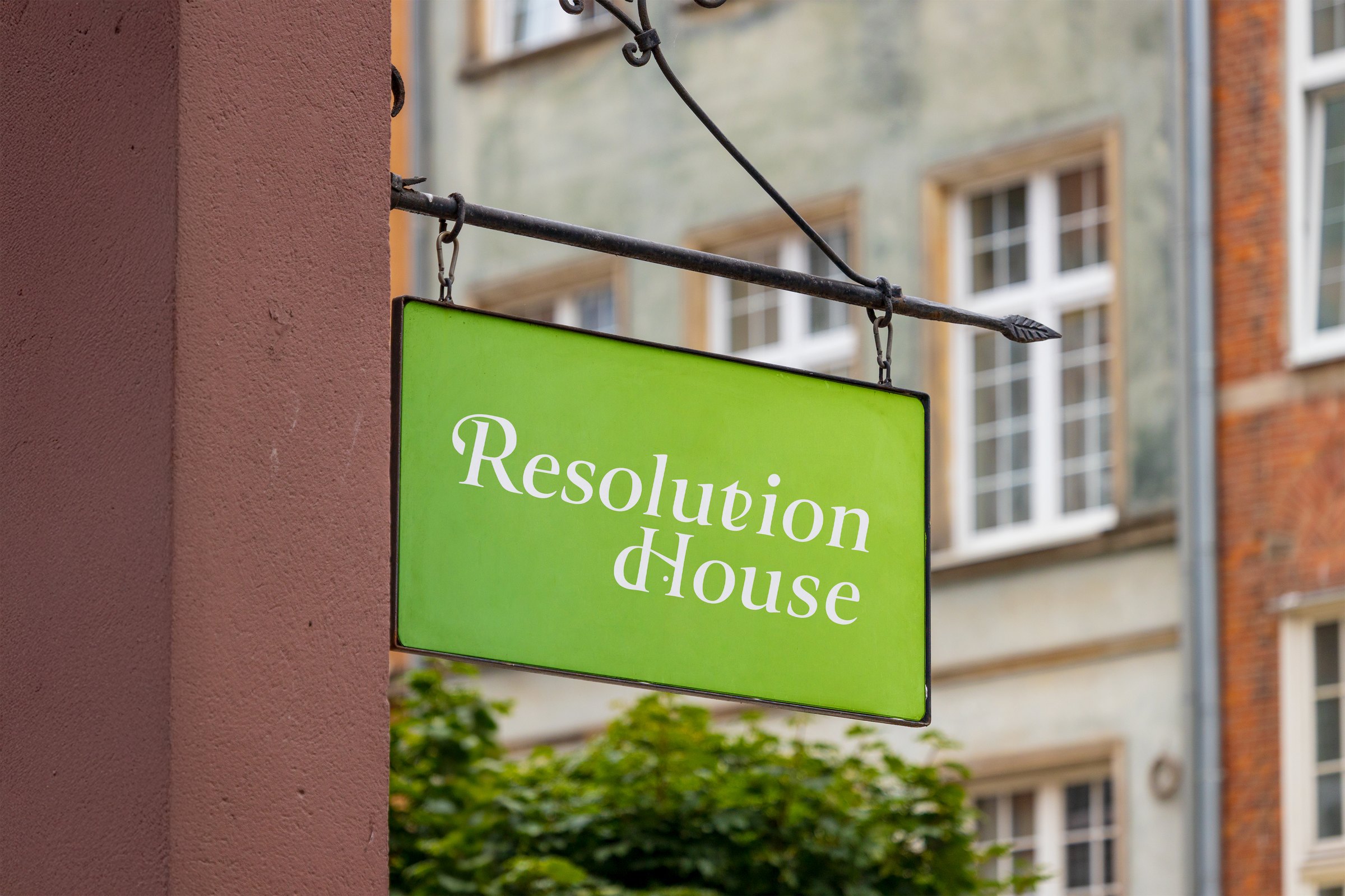 Resolution House hanging shop sign on a brick building
