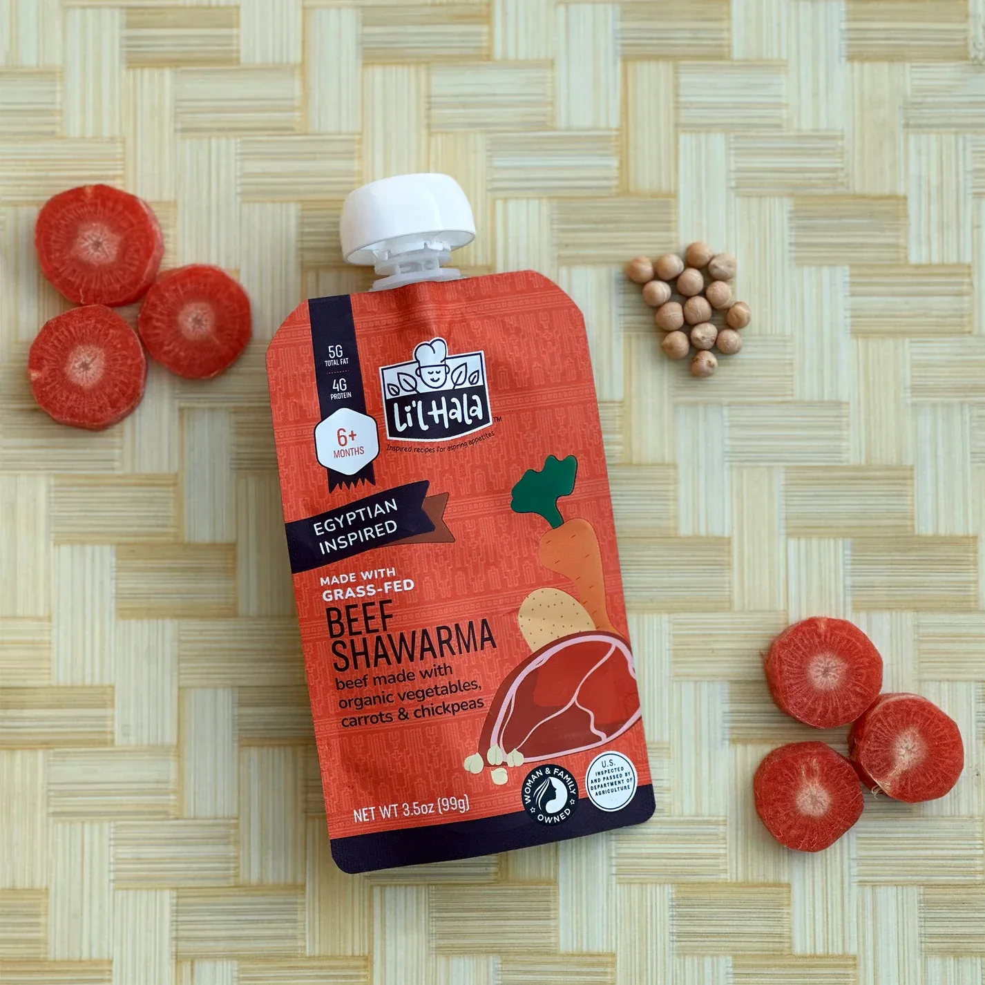 A Li'l Hala beef shawarma baby food pouch surrounded by sliced carrots and chickpeas