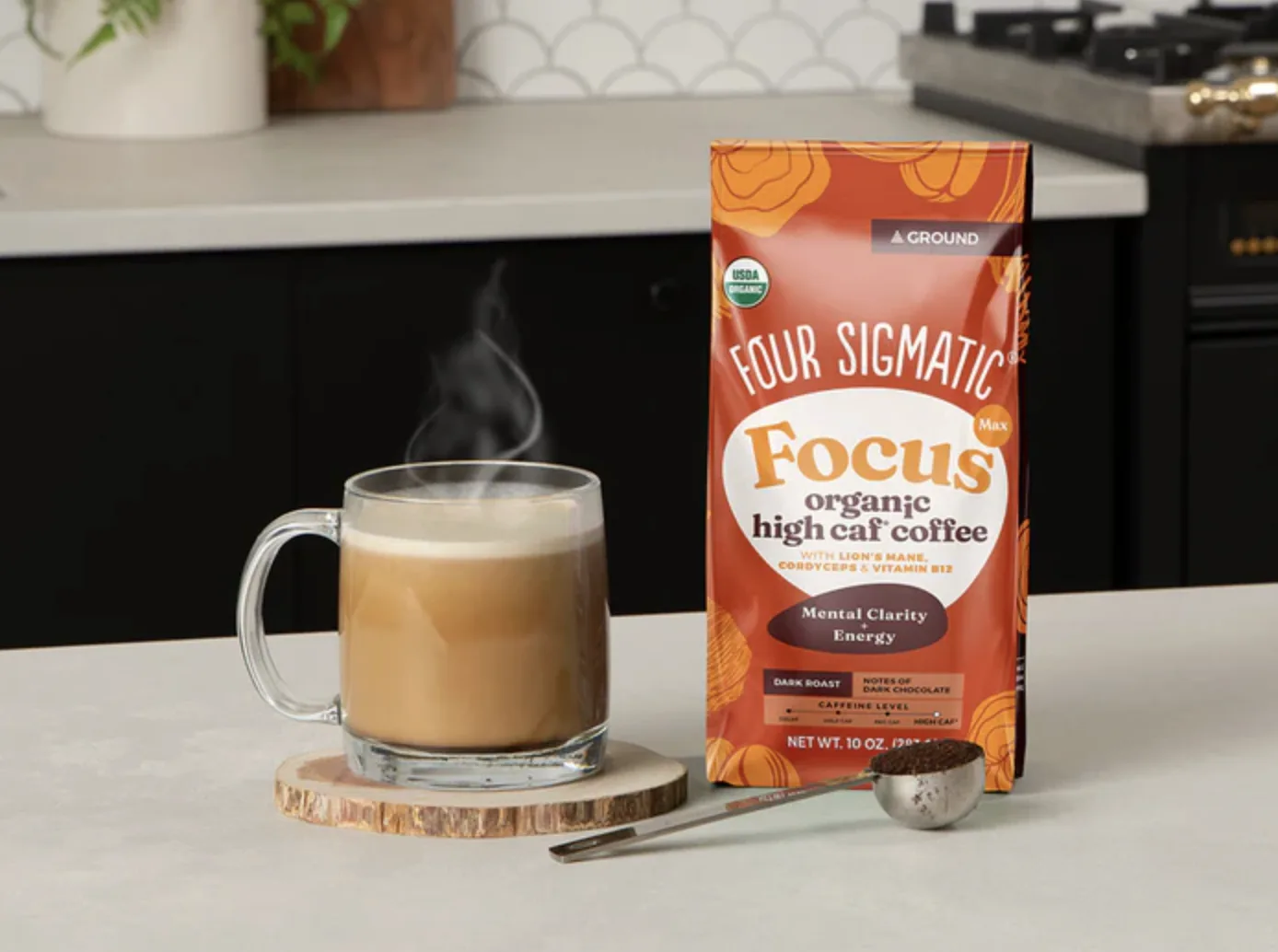 A mug of steaming coffee beside a bag of Four Sigmatic Focus organic high caf coffee on a kitchen counter