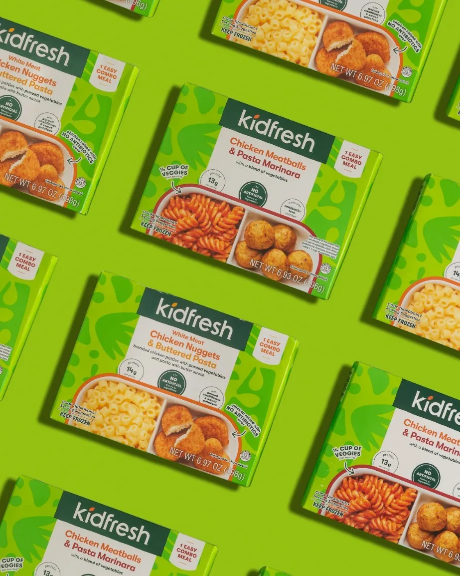 Rows of Kidfresh frozen meal trays on a bright green background