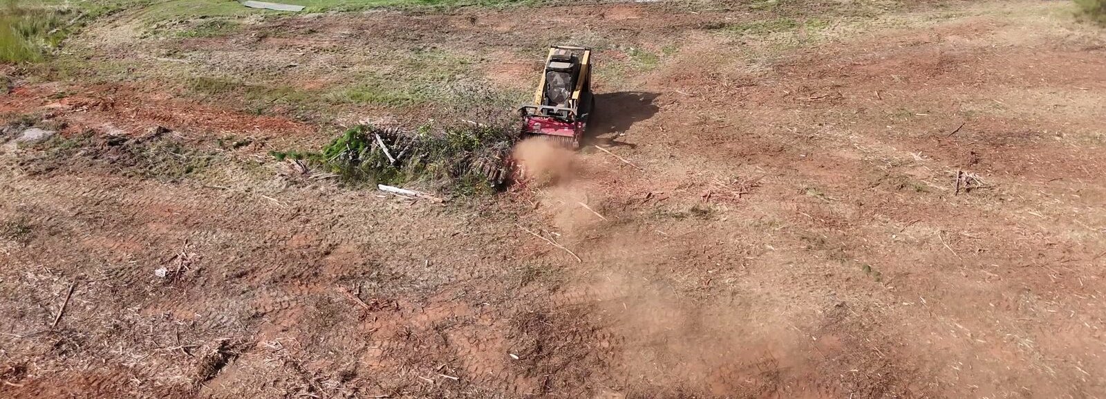 Aerial view of a forestry mulcher grinding brush into mulch on a cleared lot in Anderson, SC