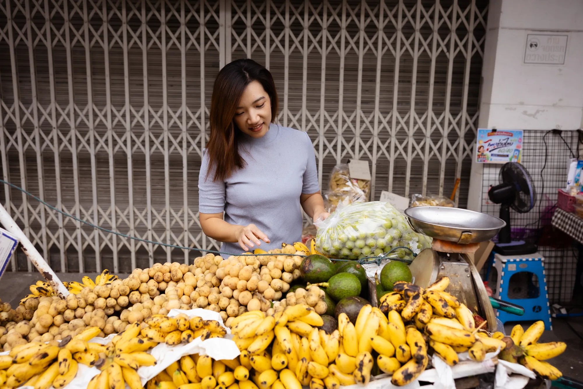 Aom choosing fruit at a Chiang Mai market