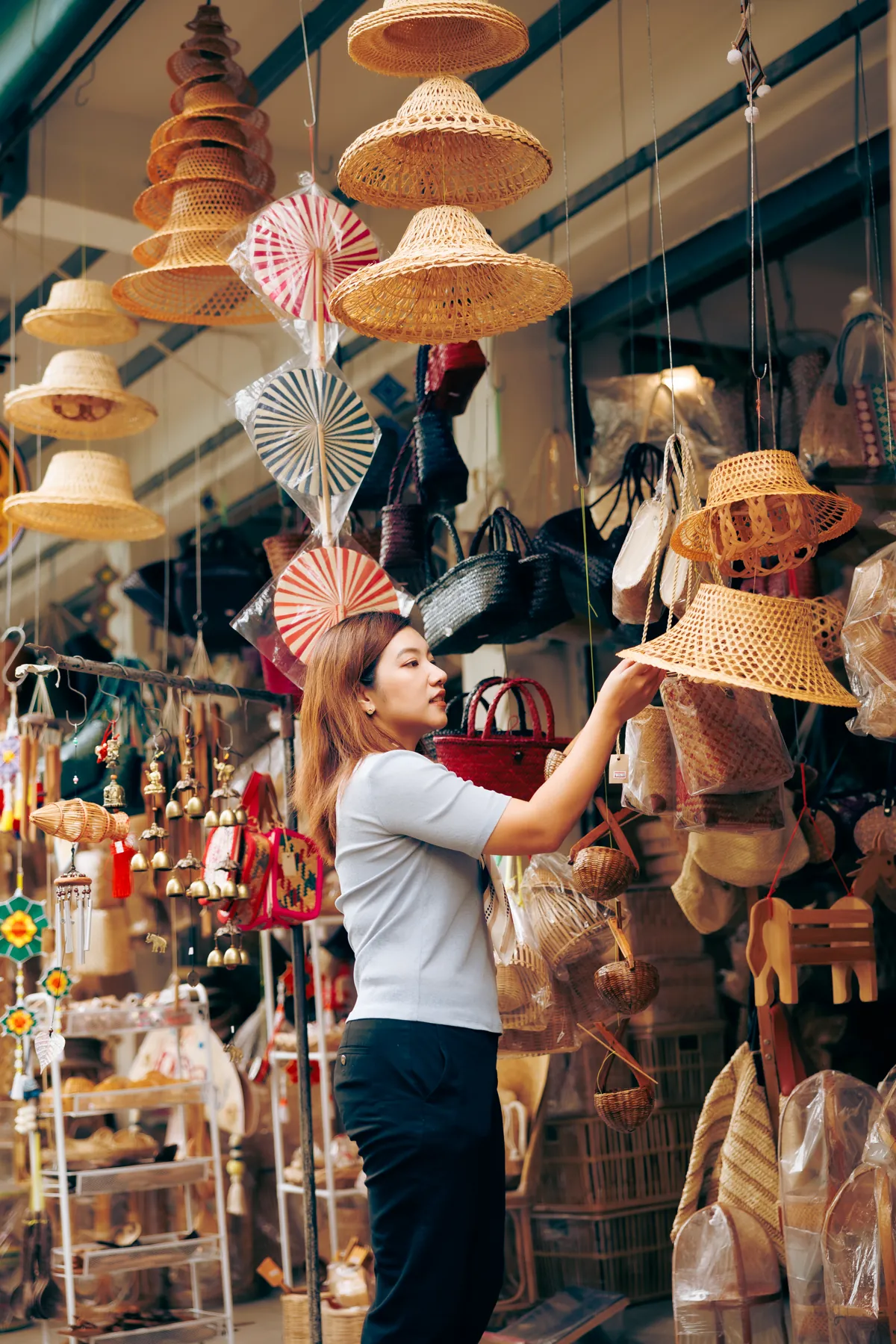 Aom browsing woven hats at a Chiang Mai craft market