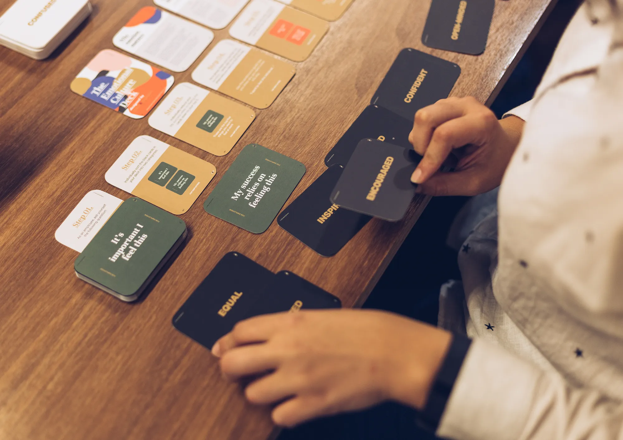 Emotional Culture Deck cards being sorted into rows on a wooden table