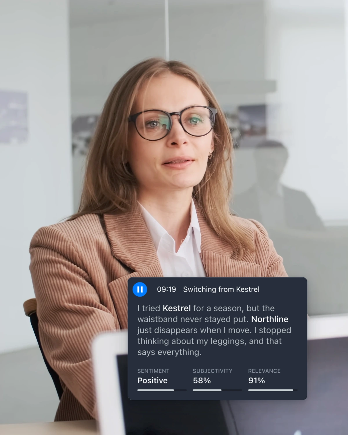 The 09:19 Key Moment card, open, with her words and its sentiment, subjectivity and relevance, beside a research participant in a glass-walled office.