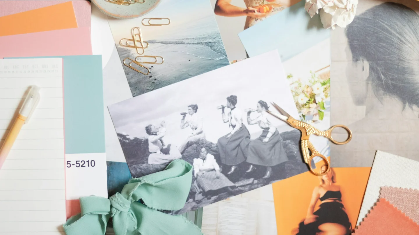 A moodboard of photos, color swatches, and fabric samples spread across a table