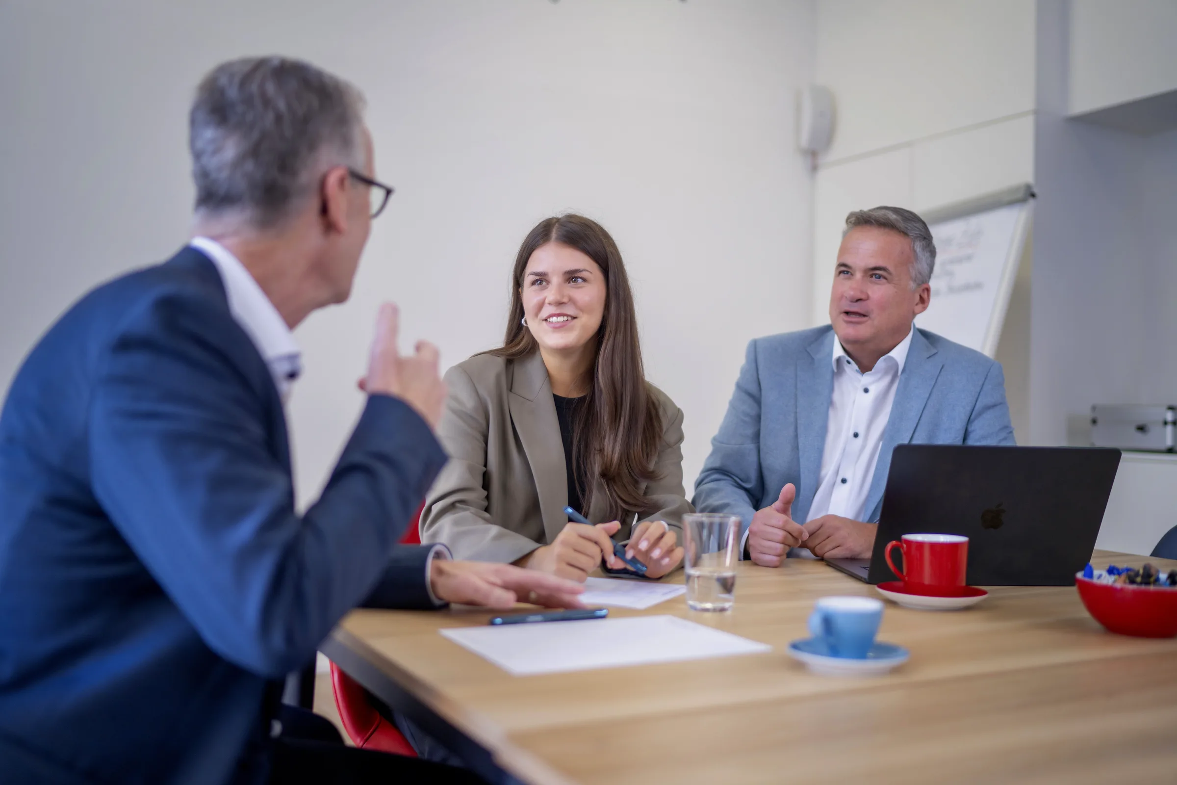 Berater im persönlichen Gespräch mit Mandanten am Besprechungstisch