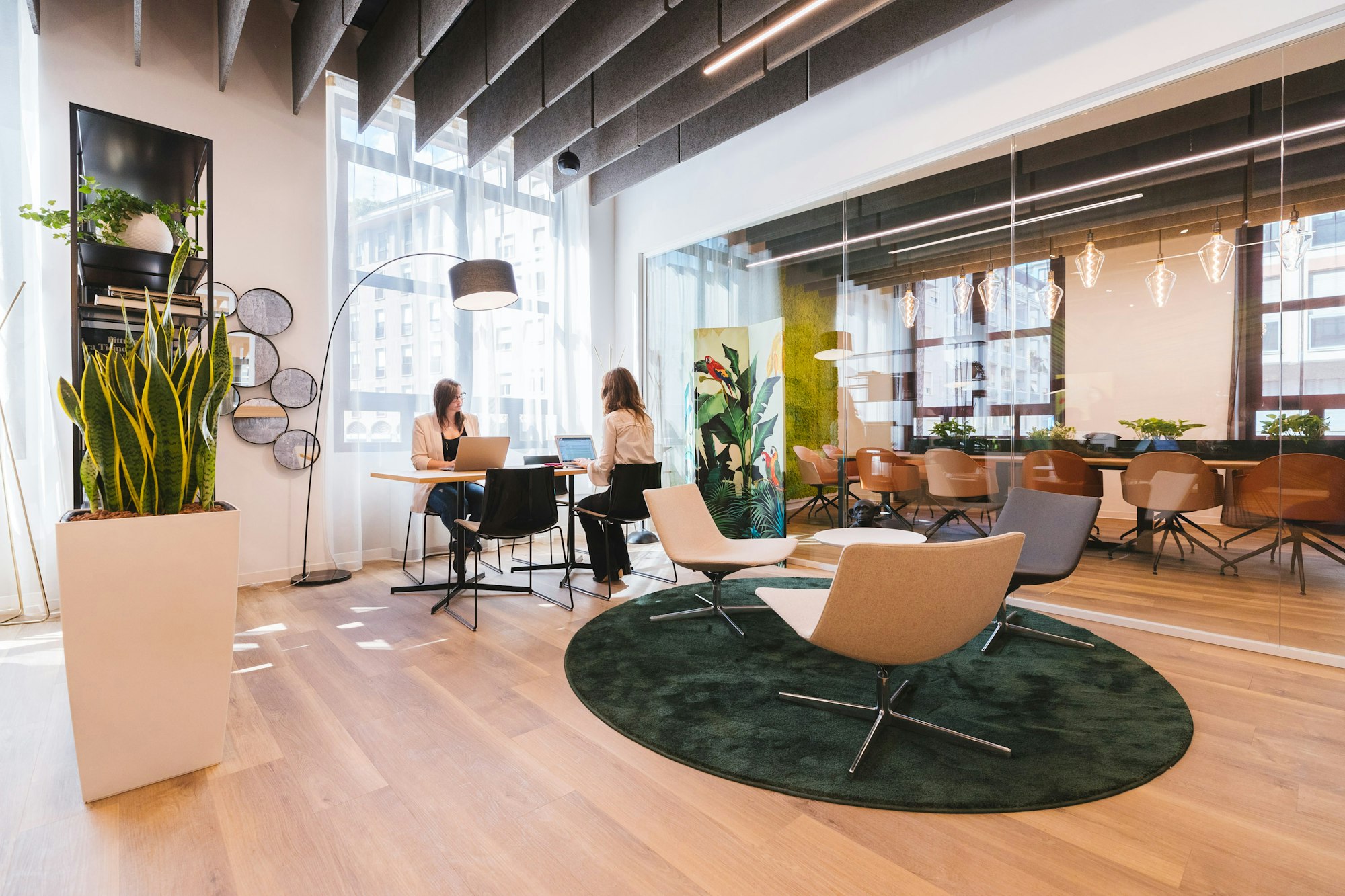 Zwei Personen arbeiten an Laptops in einem hellen, modernen Büro