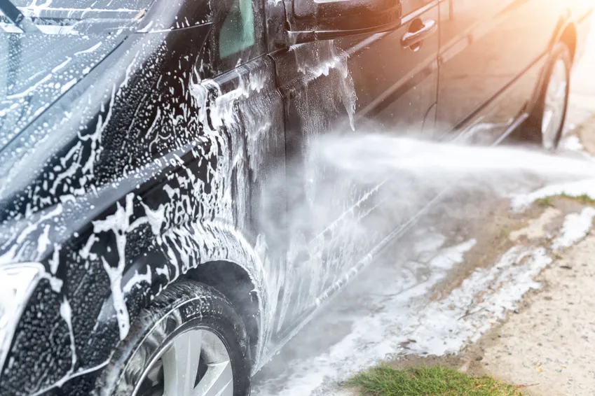 Foam being rinsed from the exterior of a work van