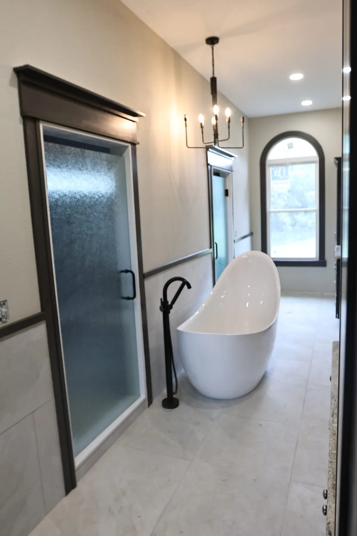 Freestanding bathtub beside a glass-enclosed shower.