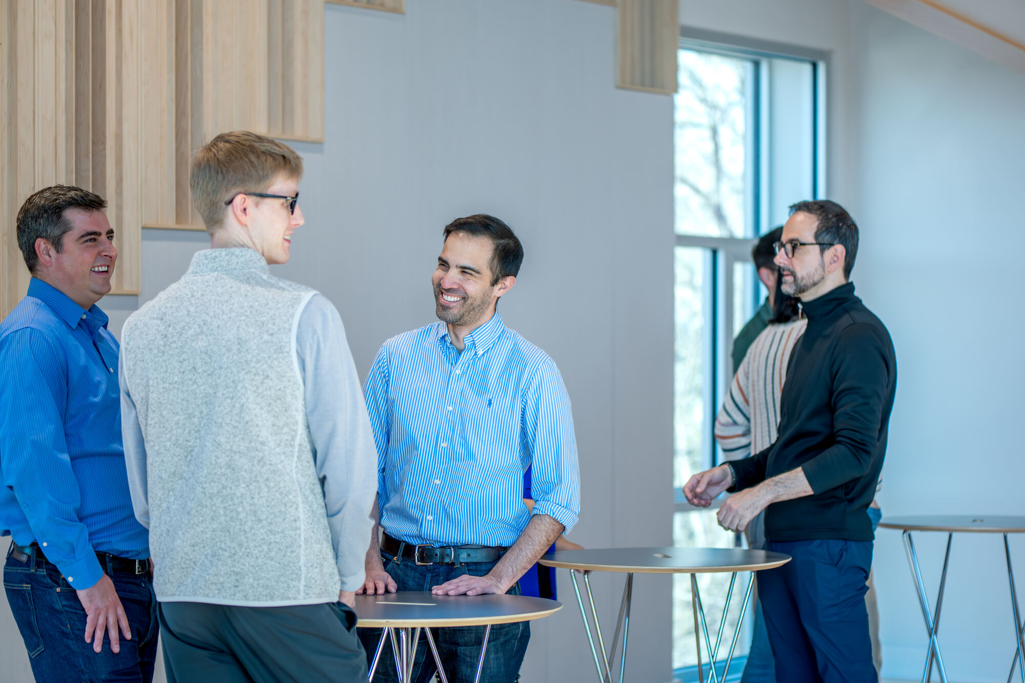 Colleagues chatting around a high-top table at a reception