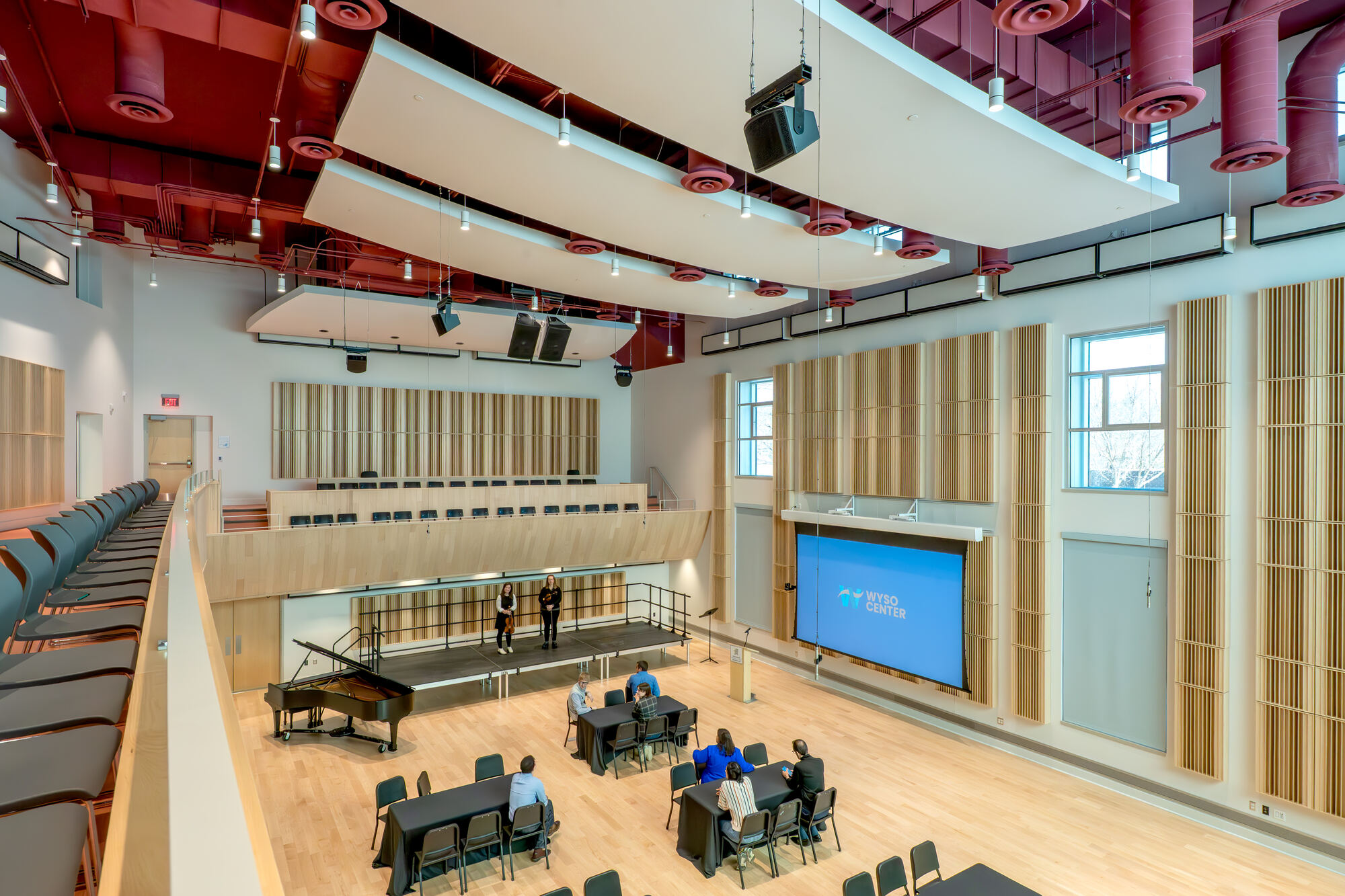 View from the balcony over Marvin Rabin Hall, with tables, stage and screen below