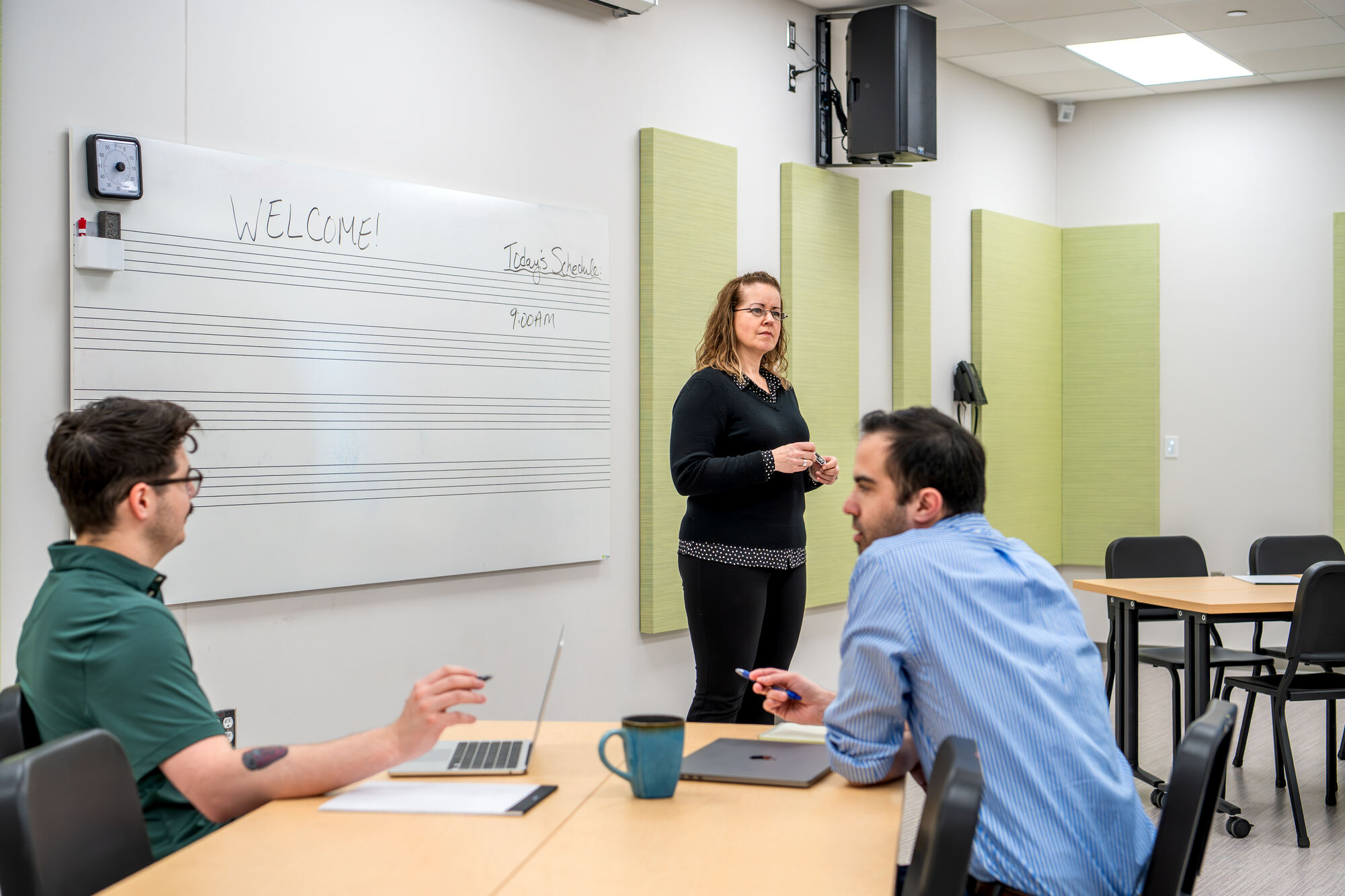 Close-up of a facilitator at the whiteboard talking with two participants