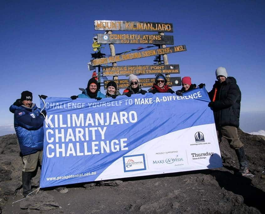 Peak Potential Adventures charity trekker standing on the summit of Mt Kilimanjaro.