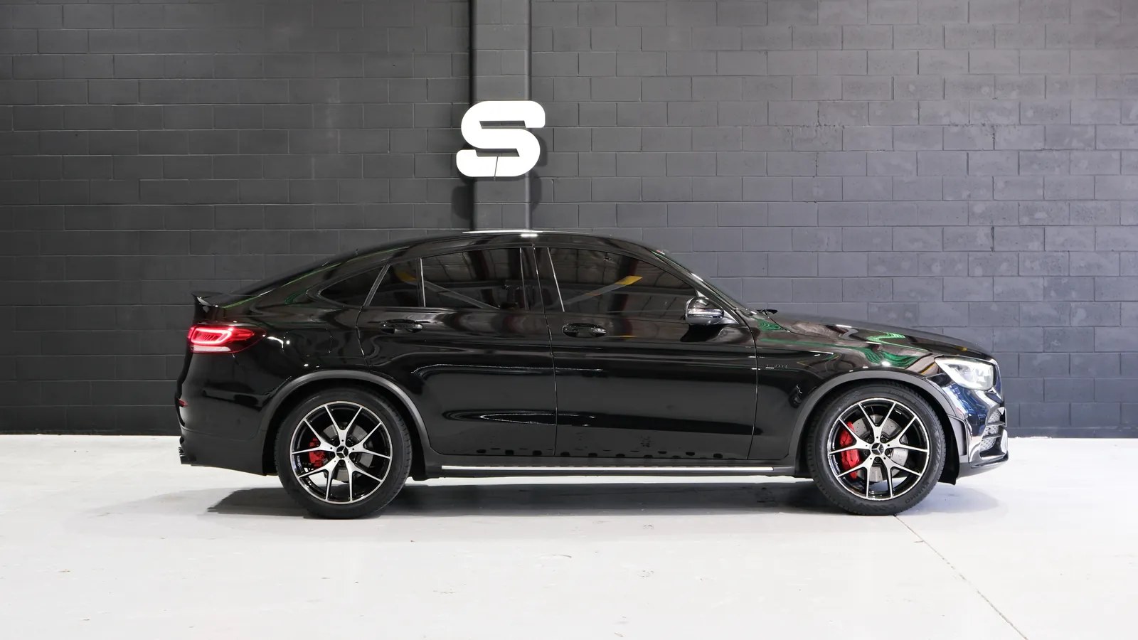 Side profile of the black 2020 Mercedes-AMG GLC 43 Coupe in the Safeway Auto showroom