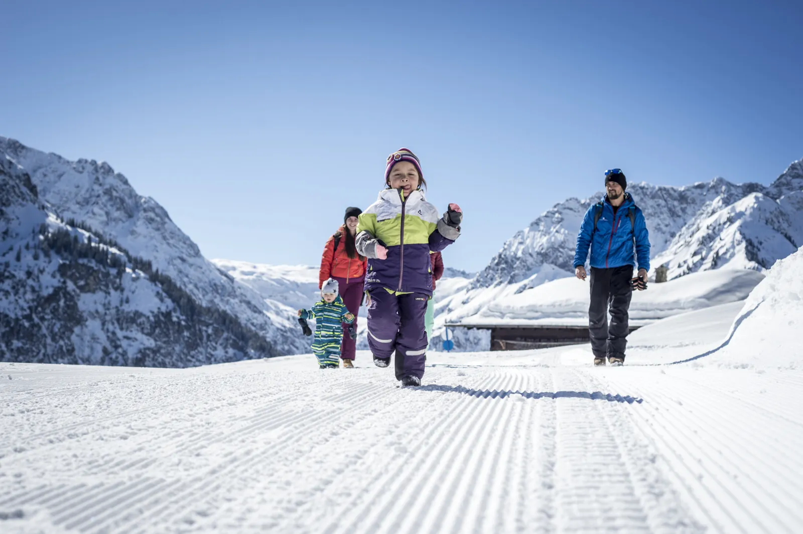 Familie beim Winterwandern auf gespurtem Weg im Kleinwalsertal