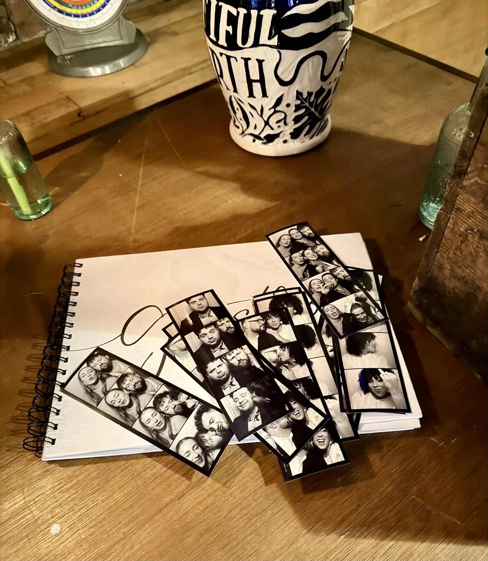 Bliss Booth photo strips laid out on a wedding guest book