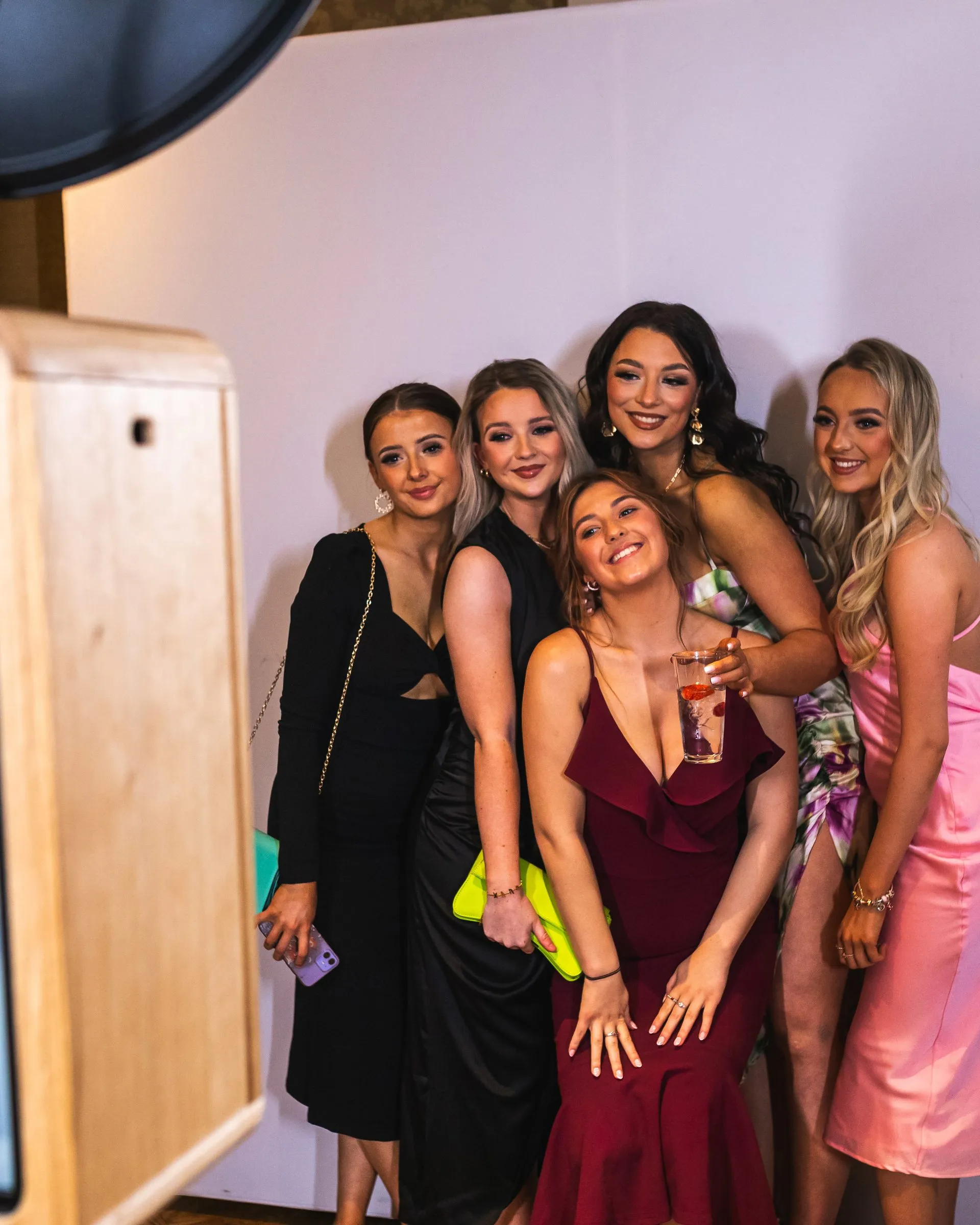 Bridesmaids and wedding guests posing together at the ICON photo booth