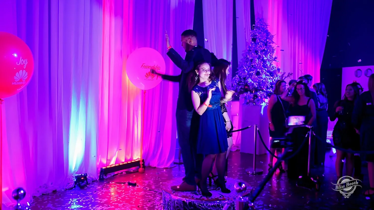 Christmas party photo booth with a festive tree and purple lighting