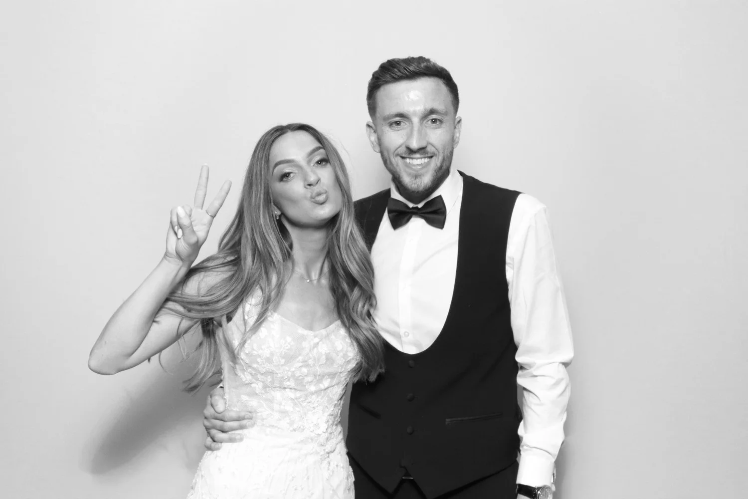 Black and white glam portrait of a guest making a peace sign